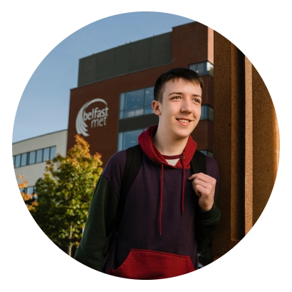 girl smiling in front of Belfast Met campus