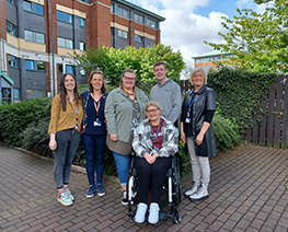 group standing side by side outside building
